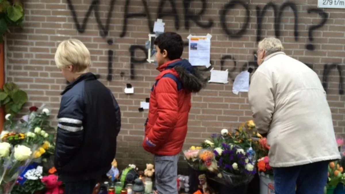 Bloemen en een vraag op de muur bij de woning